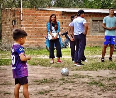 A group of people standing around a soccer ball