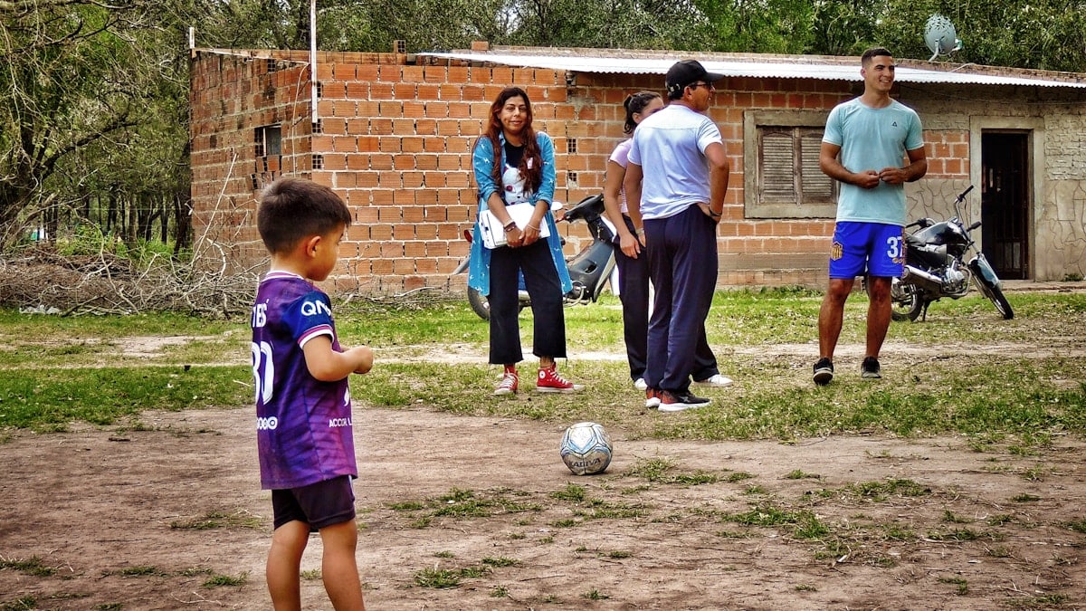 A group of people standing around a soccer ball